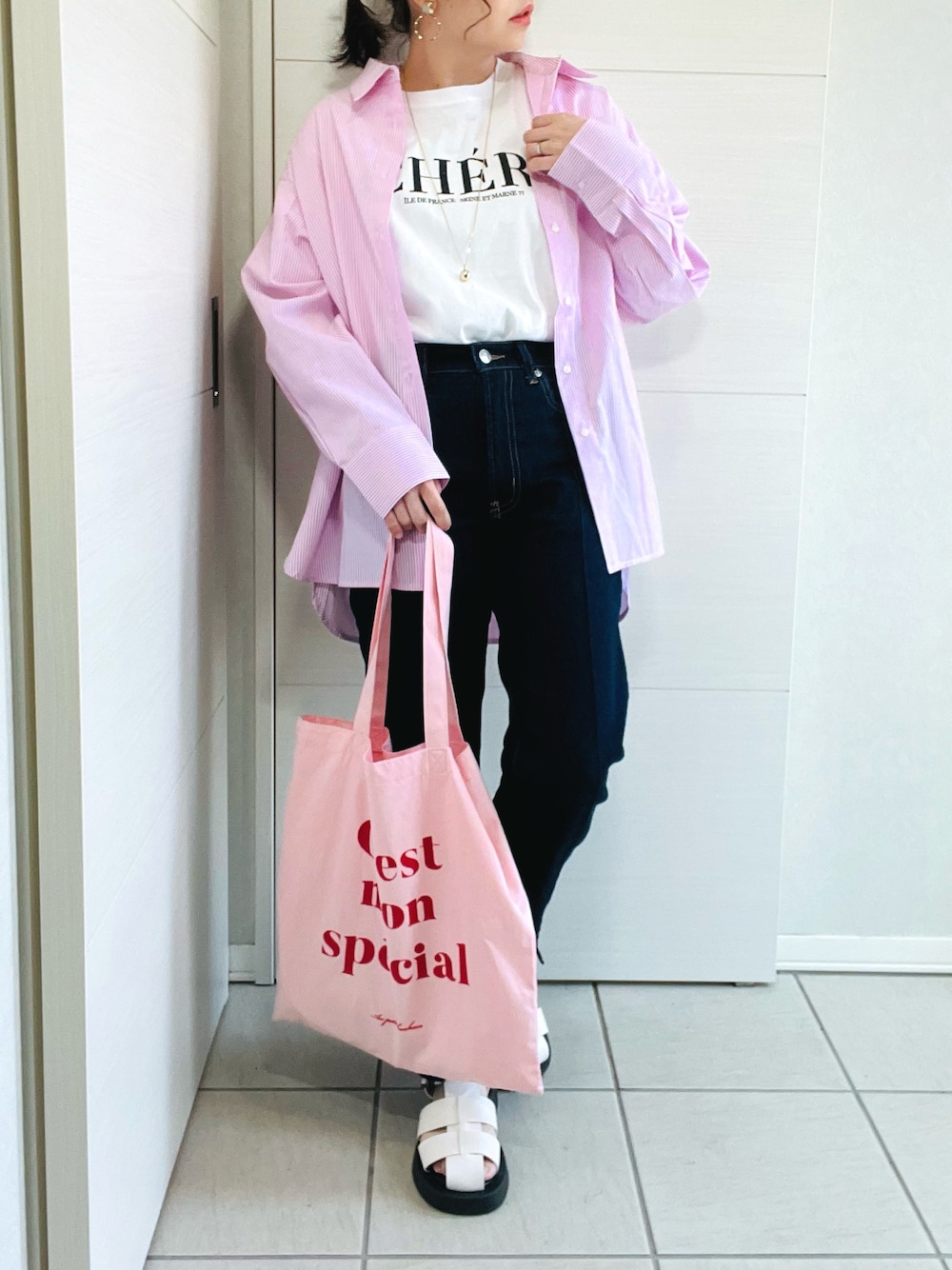 ピンク系のシャツ/ブラウス、ホワイト系のTシャツ/カットソー、ブルー系のデニムパンツを着用したレディースの春コーディネートの1枚目の写真