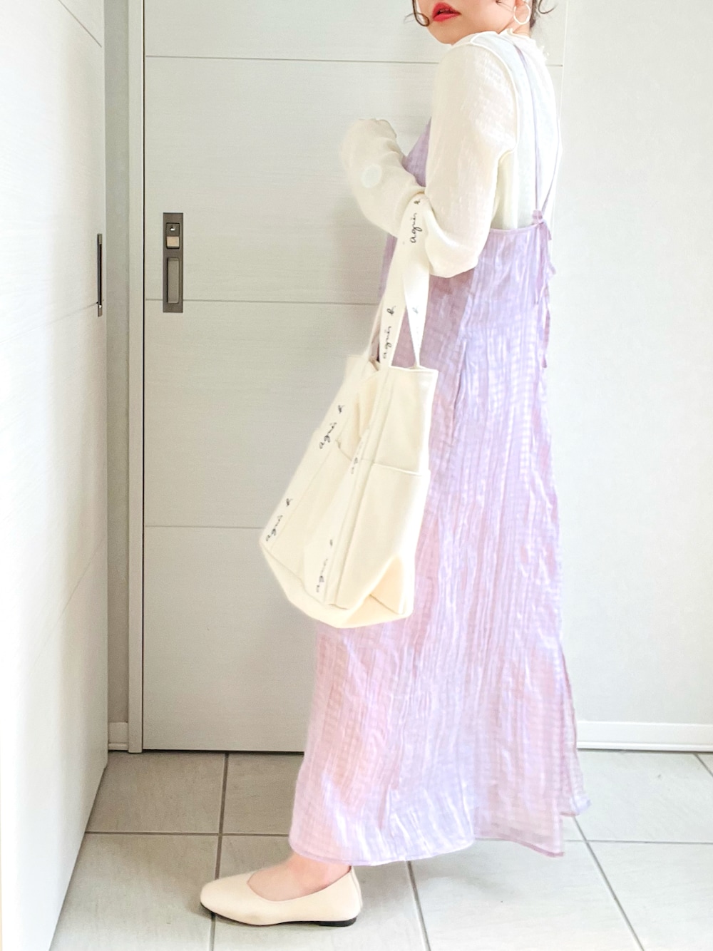 パープル系のワンピース、ホワイト系のバレエシューズ、ベージュ系のトートバッグを着用したレディースの春コーディネートの1枚目の写真