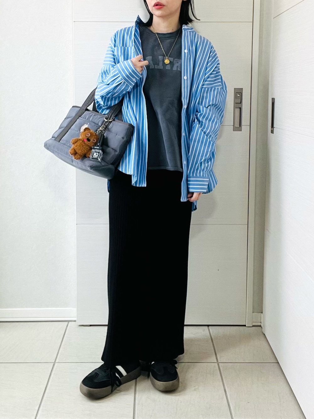 ブルー系のシャツ/ブラウス、グレー系のスウェット、ブラック系のスカートを着用したレディースの春コーディネートの1枚目の写真