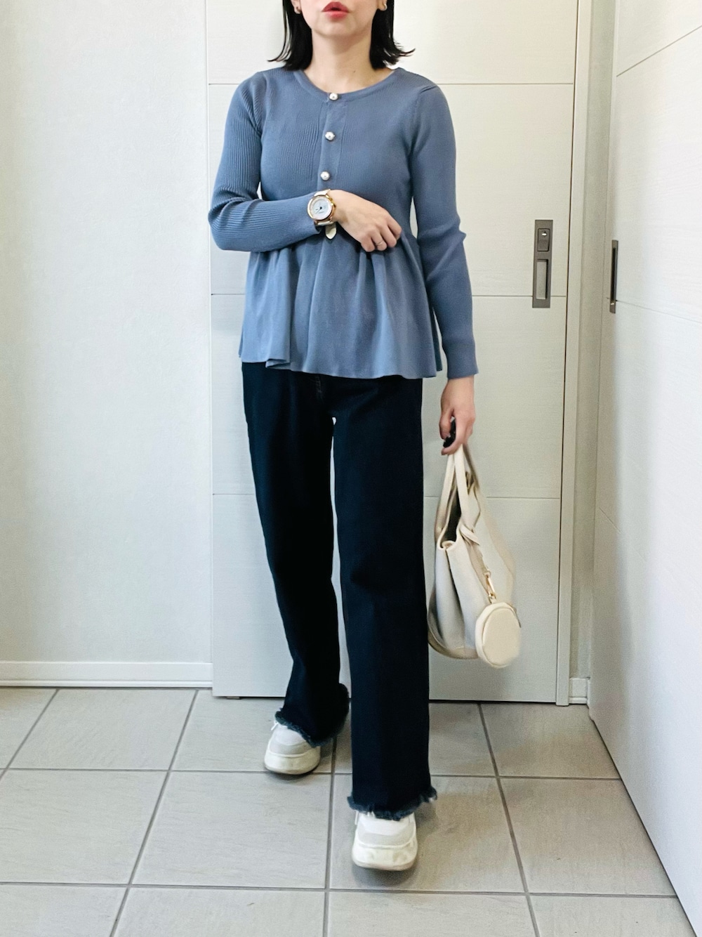 グレー系のカーディガン/ボレロ、ブルー系のデニムパンツ、ホワイト系のスニーカーを着用したレディースの春コーディネートの1枚目の写真