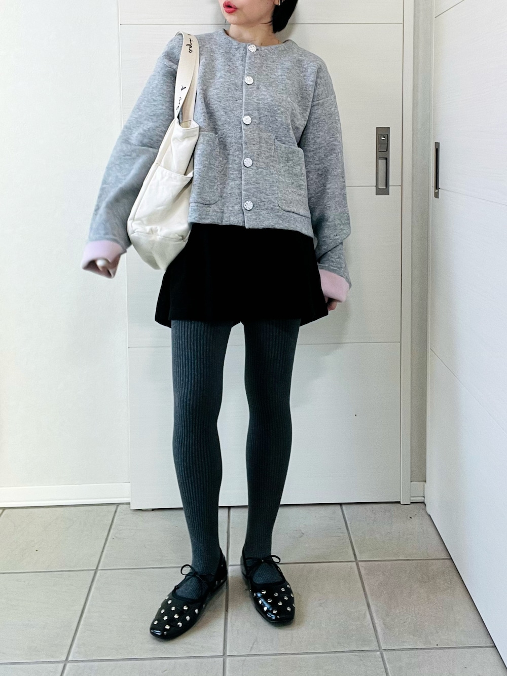グレー系のカーディガン/ボレロ、ブラック系のバレエシューズ、ベージュ系のトートバッグを着用したレディースの秋コーディネートの1枚目の写真