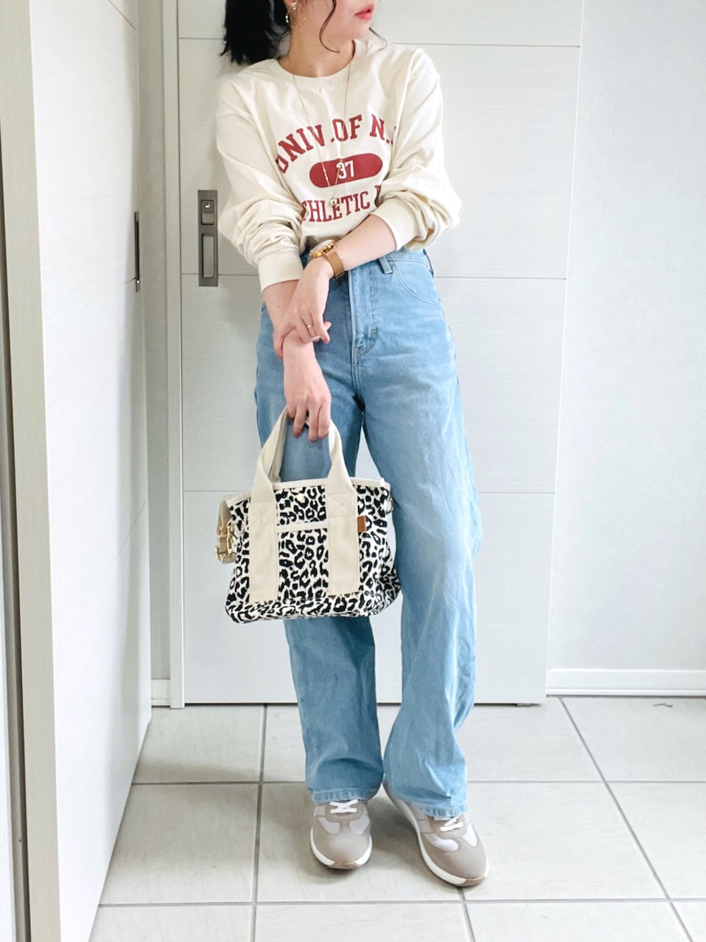 ベージュ系のTシャツ/カットソー、ブルー系のデニムパンツ、ベージュ系のスニーカーを着用したレディースの夏コーディネートの1枚目の写真