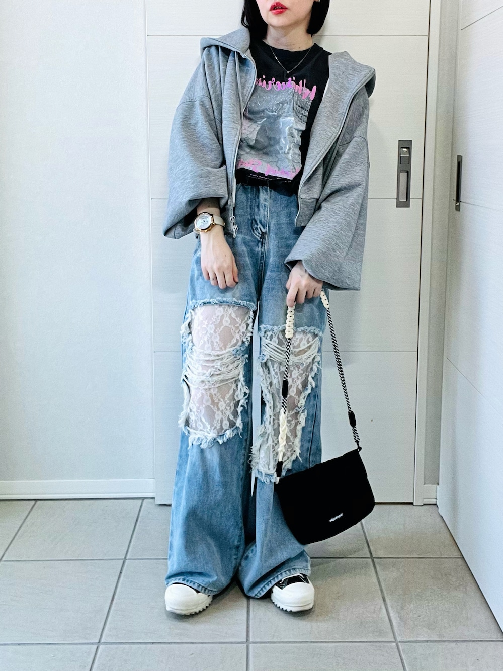 グレー系のパーカー、グレー系のTシャツ/カットソー、ブルー系のデニムパンツを着用したレディースの冬コーディネートの1枚目の写真