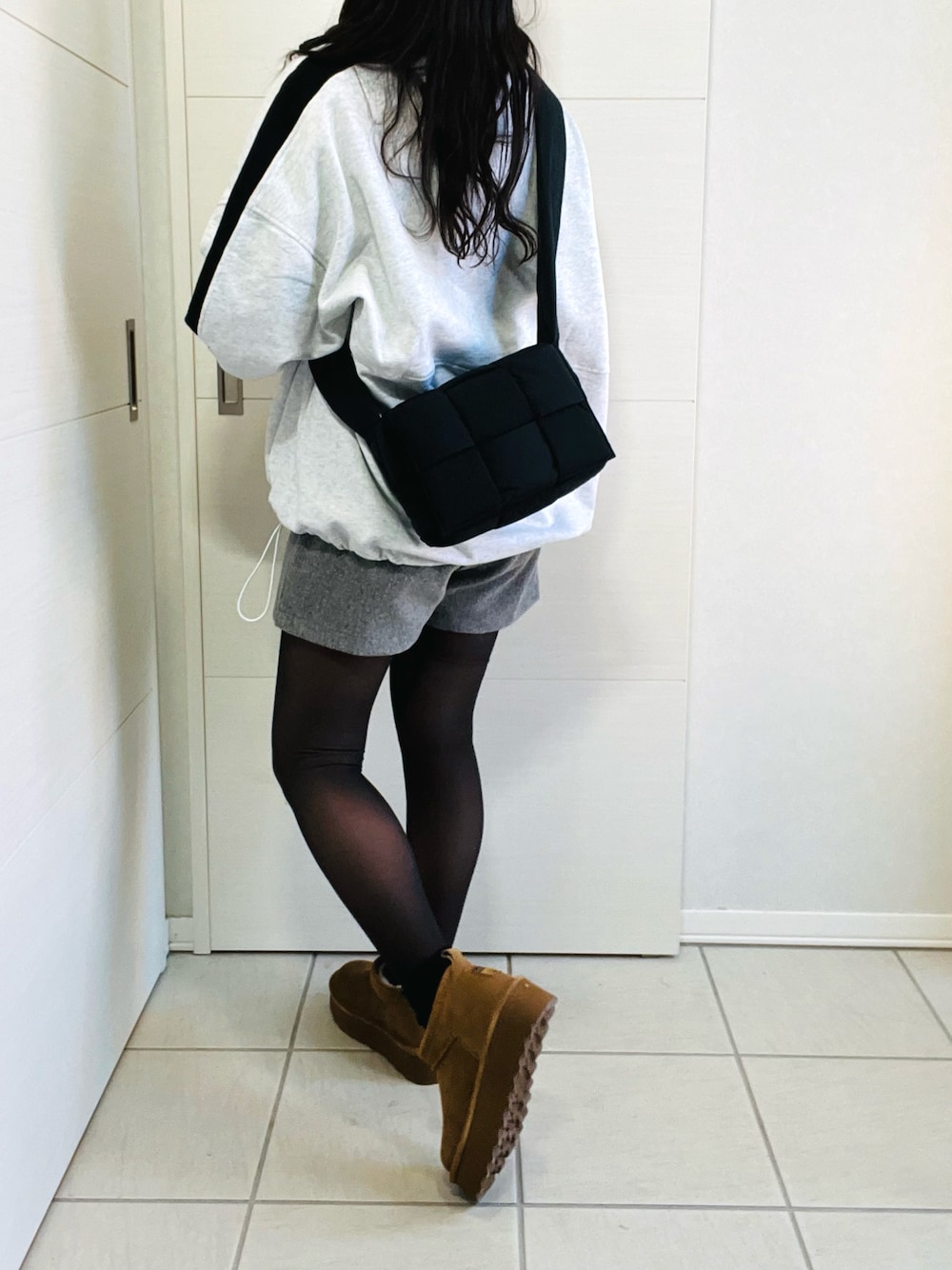 グレー系のスウェット、ブラック系のニット/セーター、グレー系のその他パンツを着用したレディースの冬コーディネートの1枚目の写真