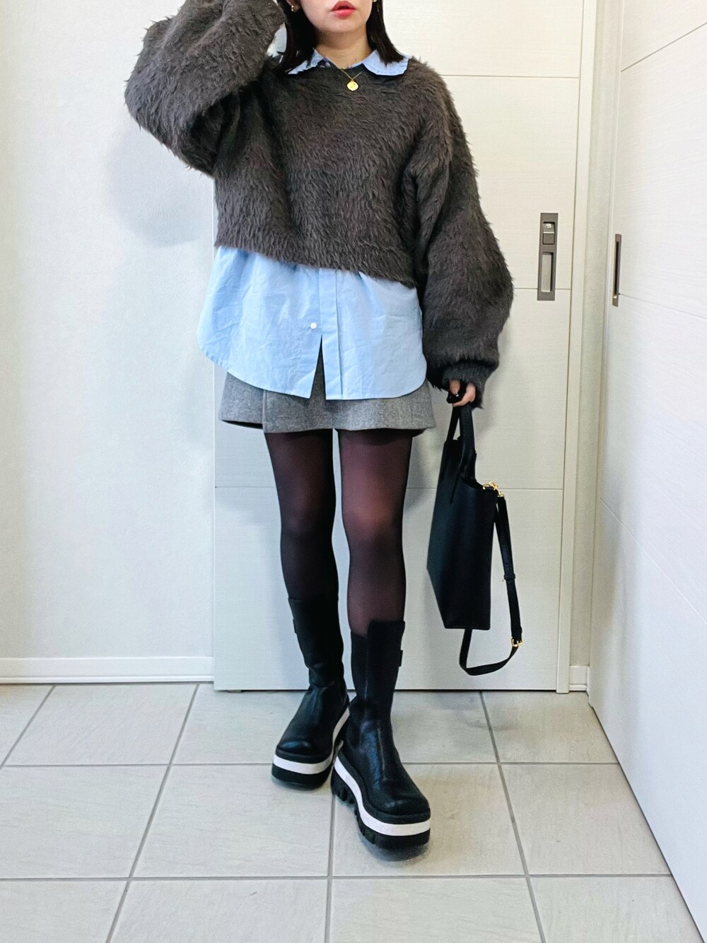 グレー系のニット/セーター、ブルー系のシャツ/ブラウス、グレー系のその他パンツを着用したレディースの冬コーディネートの1枚目の写真