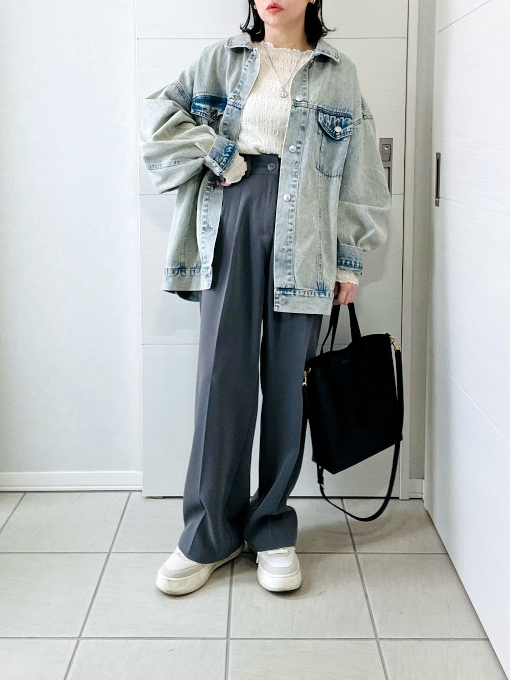 ブルー系のデニムジャケット、ホワイト系のTシャツ/カットソー、グレー系のスラックスを着用したレディースの春コーディネートの1枚目の写真