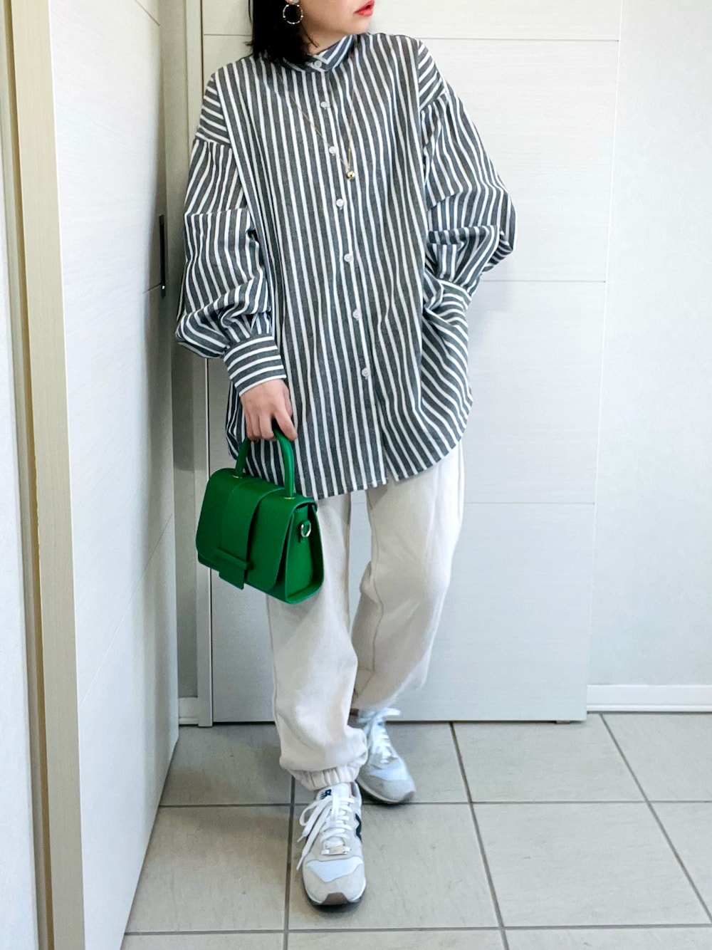 ブラック系のシャツ/ブラウス、ホワイト系のスウェットパンツ、ホワイト系のスニーカーを着用したレディースの春コーディネートの1枚目の写真