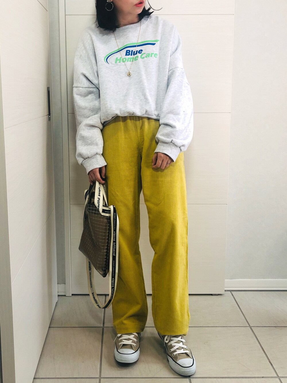 グレー系のスウェット、イエロー系のその他パンツ、ベージュ系のスニーカーを着用したレディースの秋コーディネートの1枚目の写真