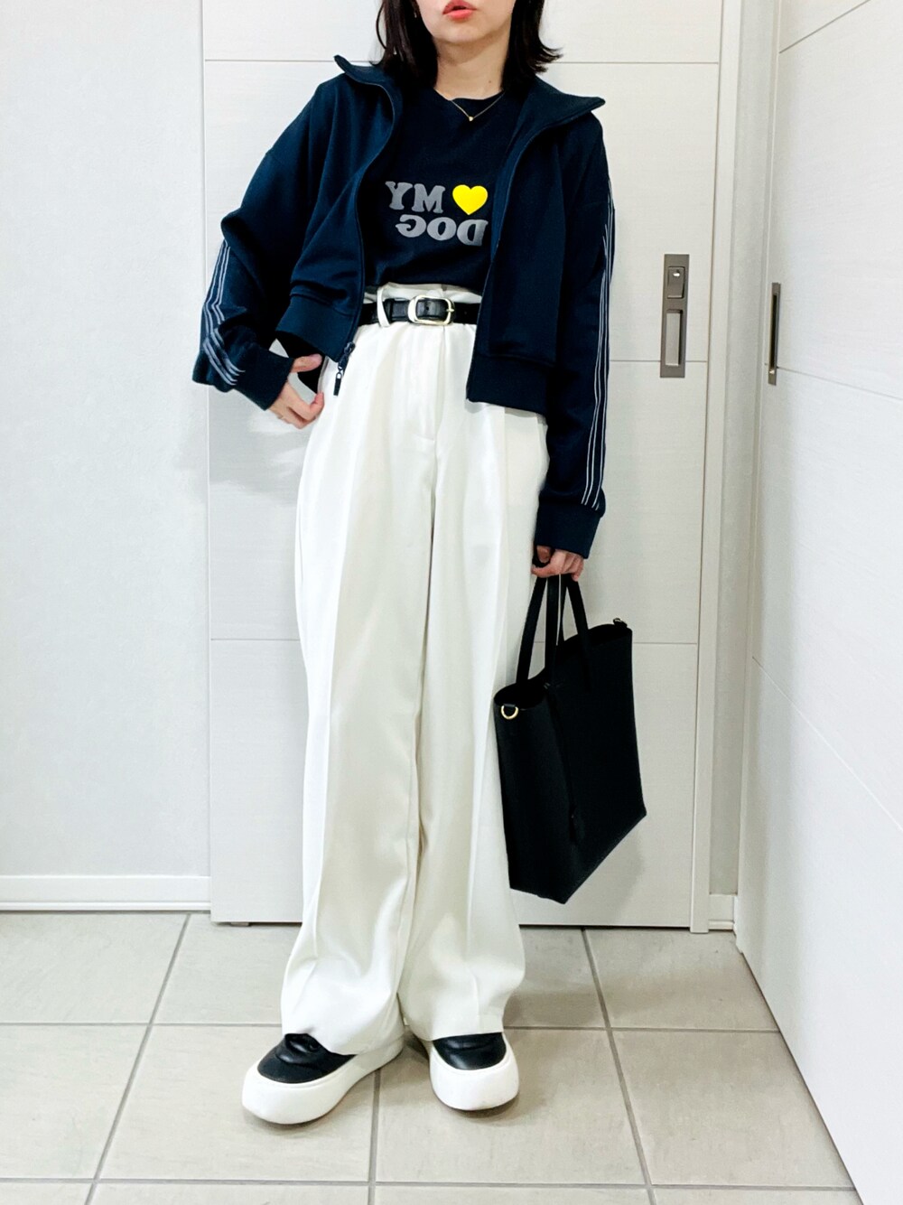ブルー系のブルゾン、ホワイト系のスラックス、ブラック系のスニーカーを着用したレディースの秋コーディネートの1枚目の写真