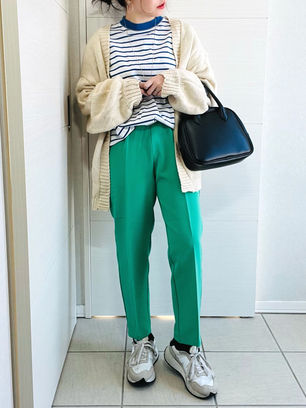 ブルー系のTシャツ/カットソー、ホワイト系のカーディガン/ボレロ、グリーン系のスラックスを着用したレディースの冬コーディネートの1枚目の写真