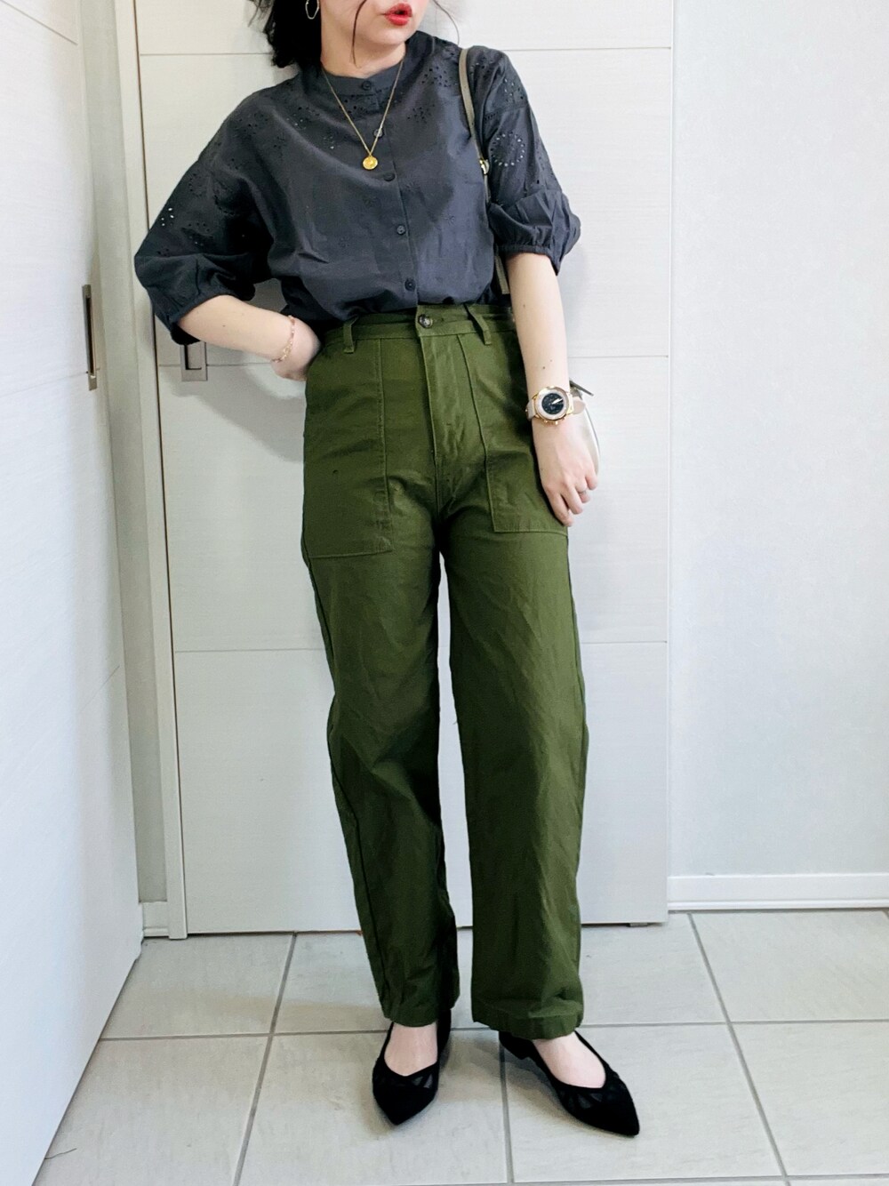 グレー系のシャツ/ブラウス、ブラック系のパンプス、ホワイト系のショルダーバッグを着用したレディースの春コーディネートの1枚目の写真
