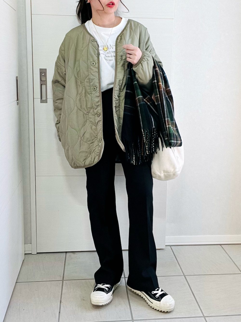 ホワイト系のTシャツ/カットソー、グリーン系のノーカラージャケット、ブラック系のスラックスを着用したレディースの冬コーディネートの1枚目の写真