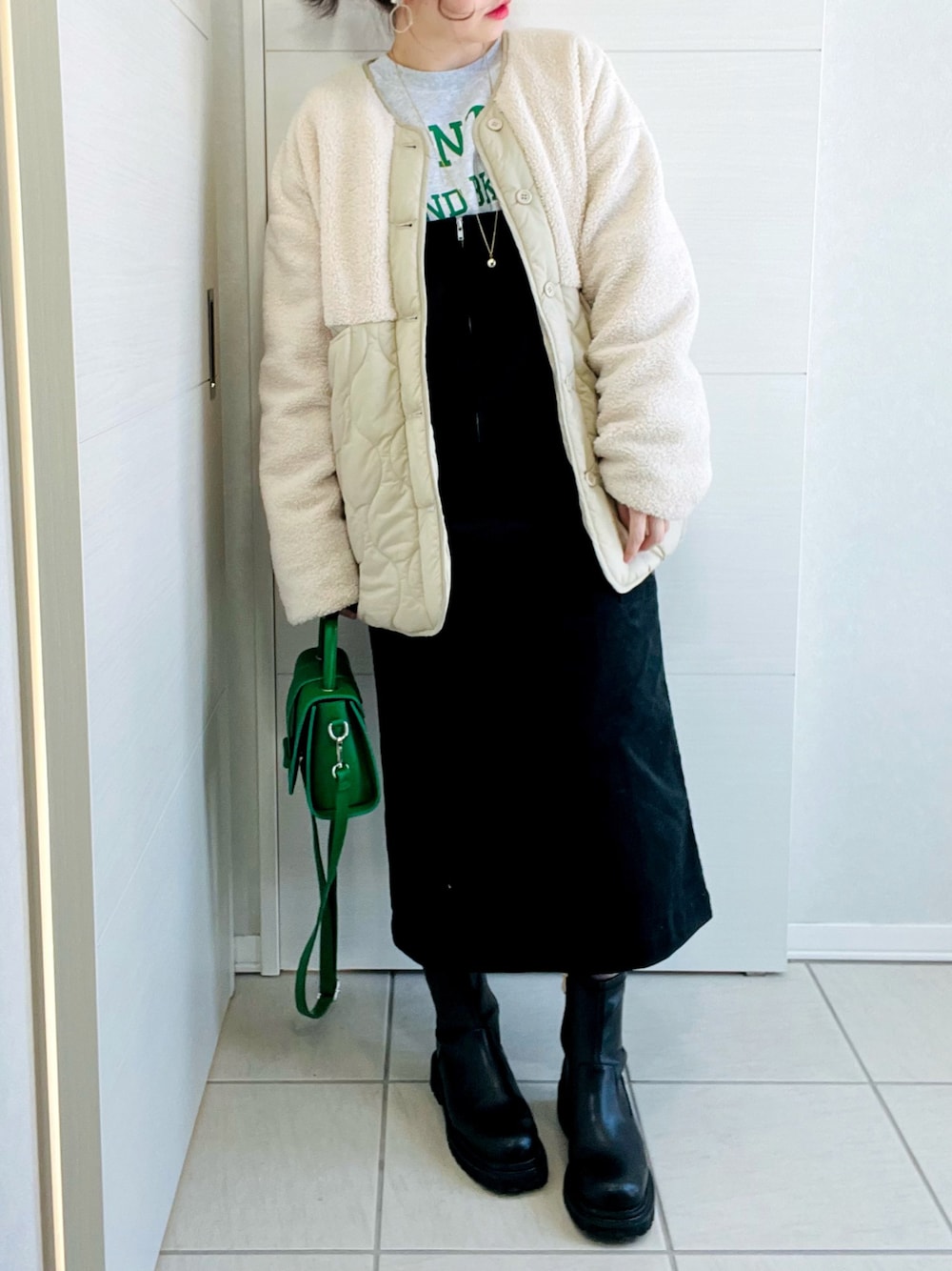 ホワイト系のその他アウター、グレー系のスウェット、ブラック系のジャンパースカートを着用したレディースの冬コーディネートの1枚目の写真