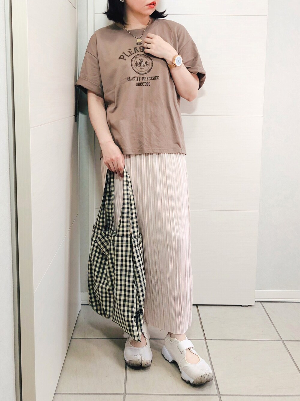 ブラウン系のTシャツ/カットソー、ホワイト系のスカート、ホワイト系のサンダルを着用したレディースの夏コーディネートの1枚目の写真