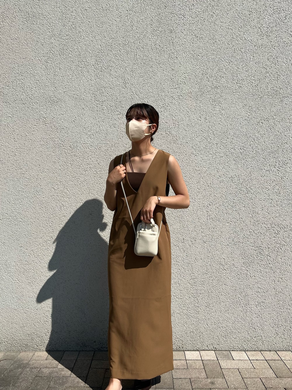 ブラウン系のジャンパースカート、ホワイト系のショルダーバッグ、その他のアナログ腕時計を着用したレディースの夏コーディネートの1枚目の写真