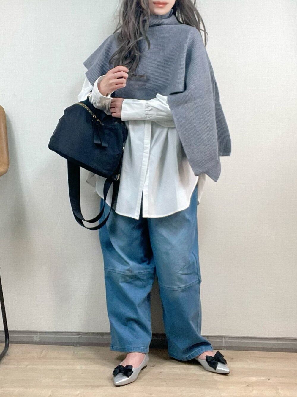 ブルー系のデニムパンツ、ブラック系のショルダーバッグ、シルバー系のパンプスを着用したレディースの冬コーディネートの1枚目の写真