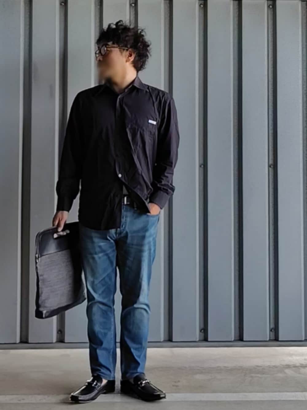 ブラック系のローファー、ブルー系のデニムパンツ、その他のクラッチバッグを着用したメンズの秋コーディネートの1枚目の写真