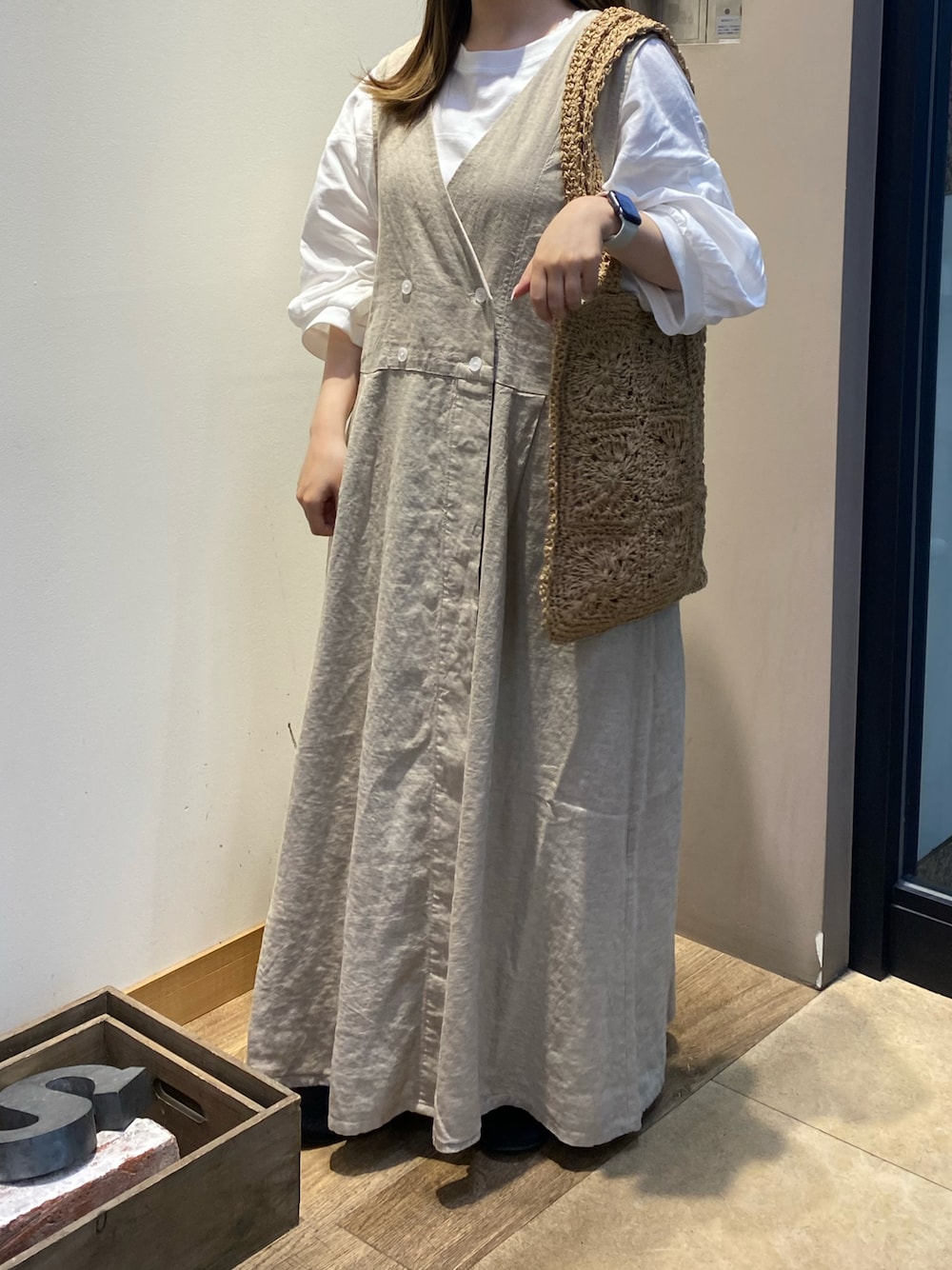 ベージュ系のワンピース、ベージュ系のハンドバッグを着用したレディースの春コーディネートの1枚目の写真