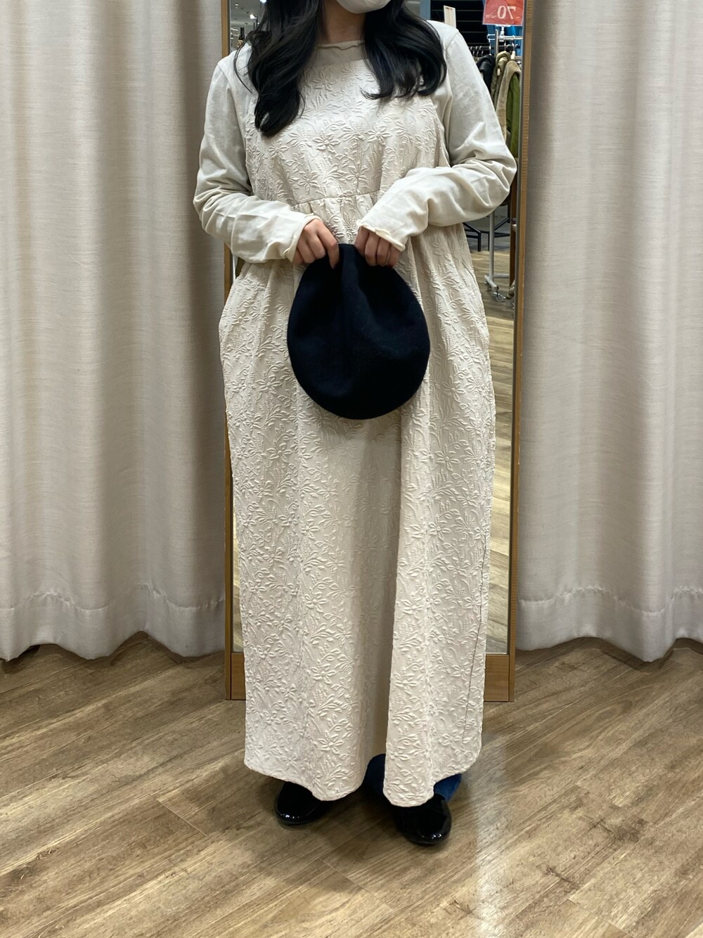 ホワイト系のワンピース、ブラック系のハットを着用したレディースの冬コーディネートの1枚目の写真