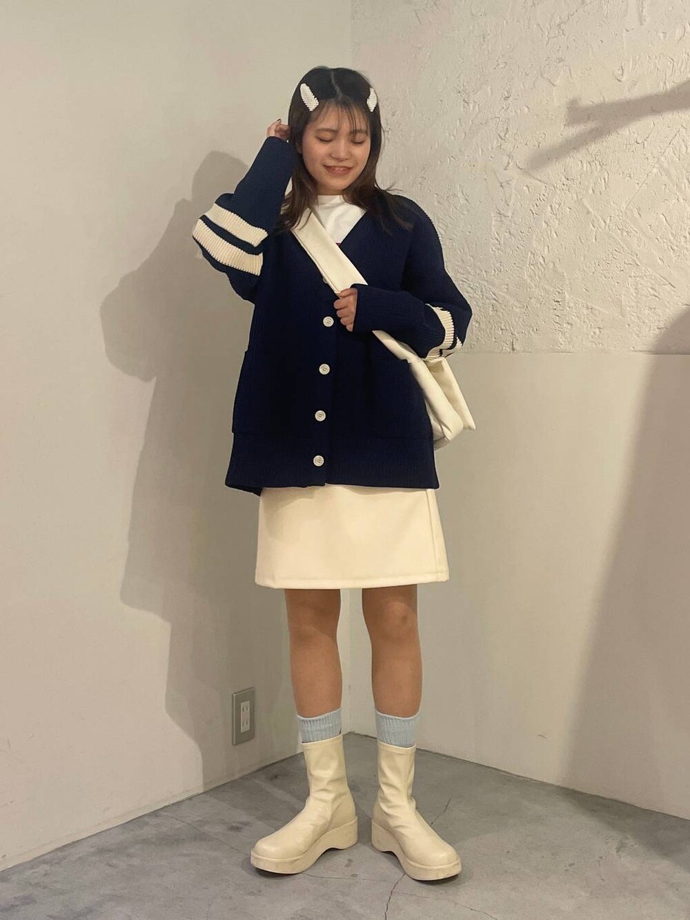 ホワイト系のブーツ、ホワイト系のTシャツ/カットソー、ホワイト系のショルダーバッグを着用したレディースの冬コーディネートの1枚目の写真