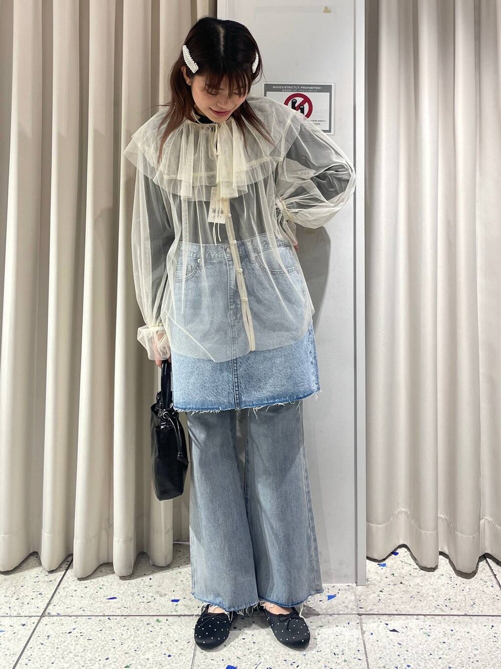 グレー系のニット/セーター、ブルー系のデニムパンツ、ブルー系のスカートを着用したレディースの冬コーディネートの1枚目の写真