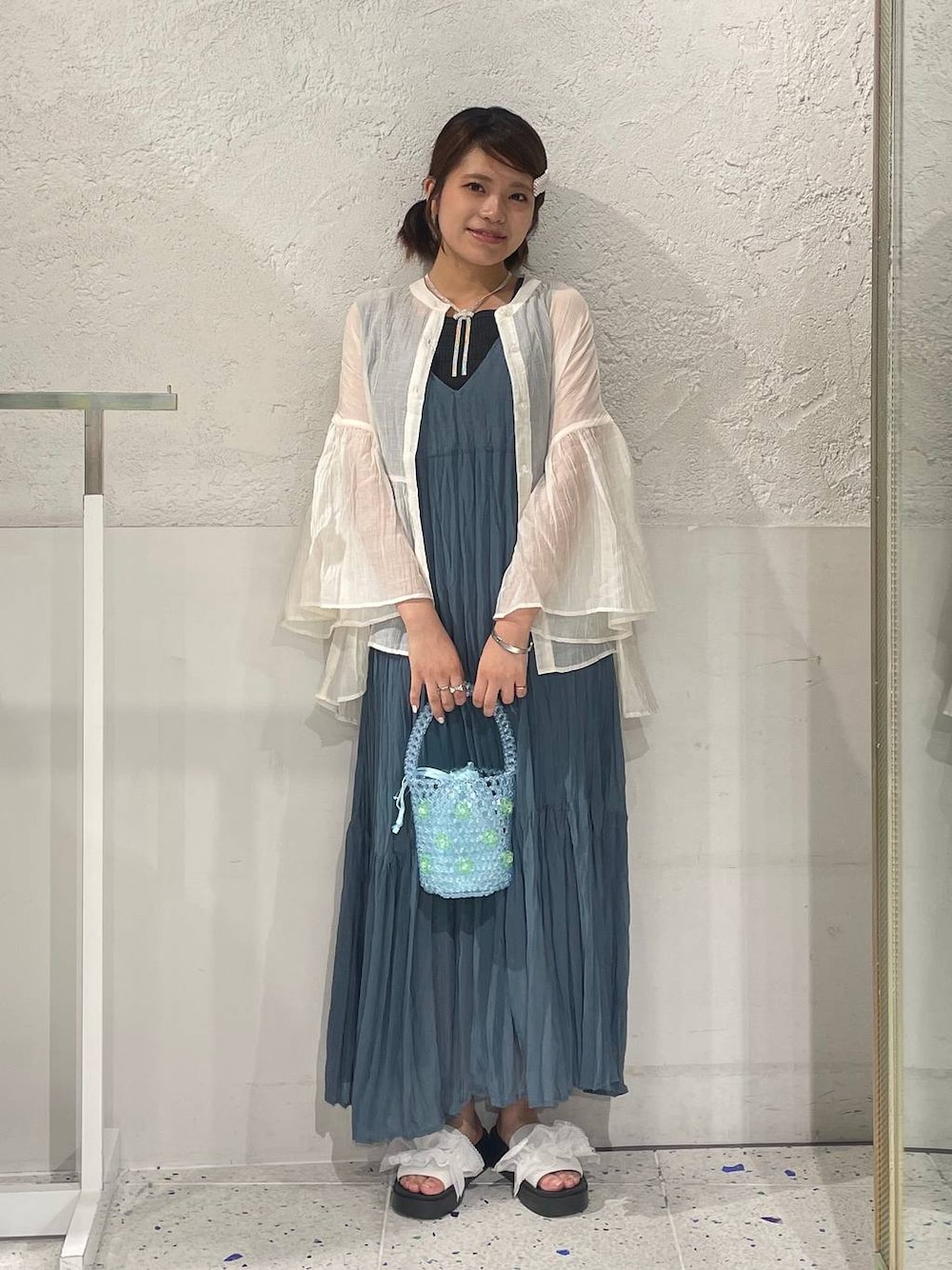 ホワイト系のサンダル、ブルー系のワンピース、ブルー系のハンドバッグを着用したレディースの夏コーディネートの1枚目の写真