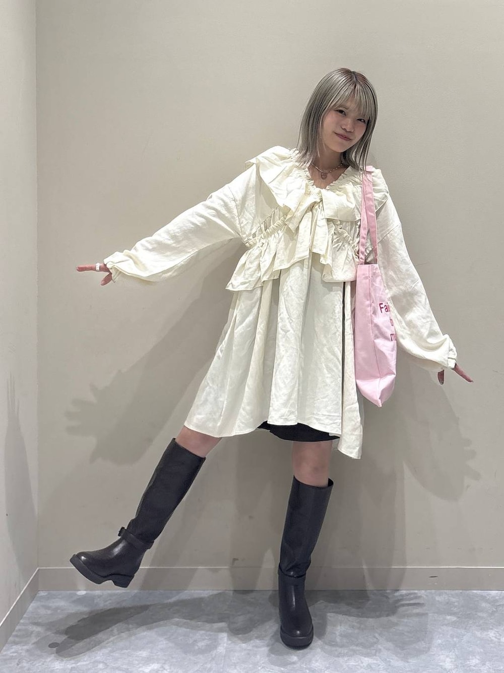 ブラック系のその他パンツ、ブラウン系のブーツ、ピンク系のトートバッグを着用したレディースの冬コーディネートの1枚目の写真