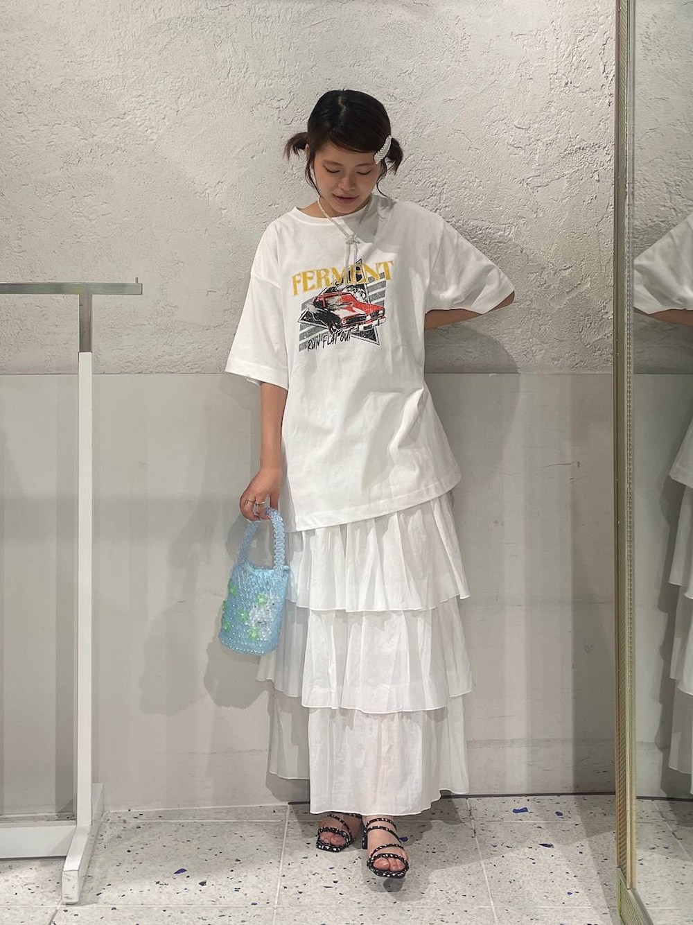 ブラック系のサンダル、ホワイト系のTシャツ/カットソー、ブルー系のハンドバッグを着用したレディースの夏コーディネートの1枚目の写真