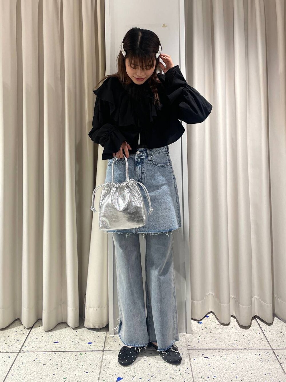 グレー系のニット/セーター、ブラック系のシャツ/ブラウス、ブルー系のデニムパンツを着用したレディースの冬コーディネートの1枚目の写真