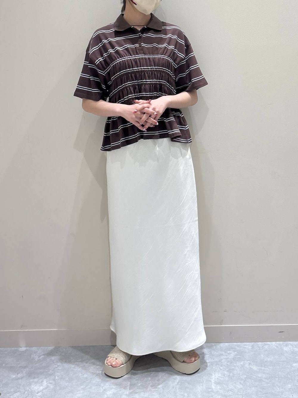 ホワイト系のスカート、ホワイト系のサンダル、ブラウン系のTシャツ/カットソーを着用したレディースの夏コーディネートの1枚目の写真