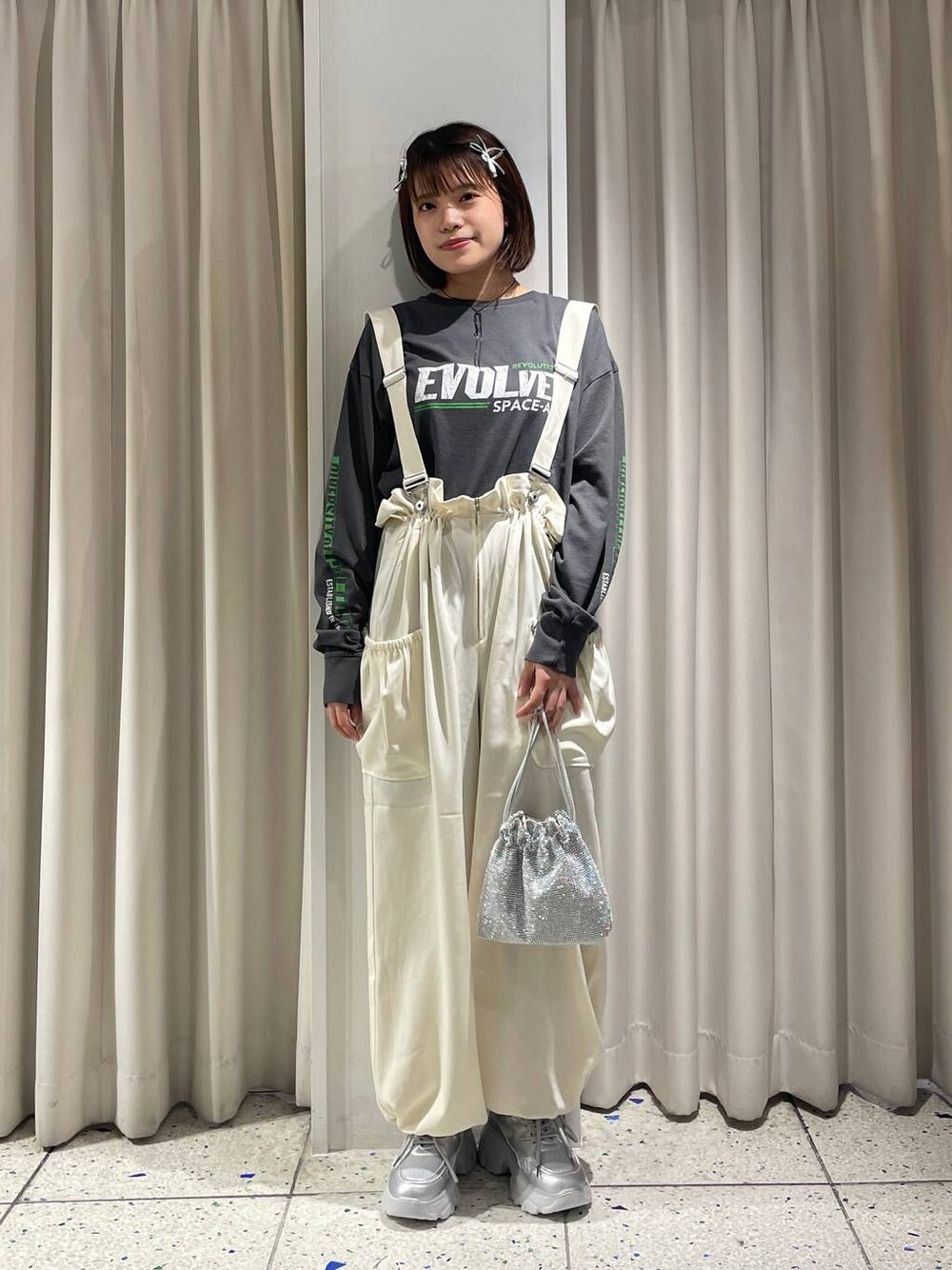 ホワイト系のワンピース、シルバー系のスニーカー、シルバー系のショルダーバッグを着用したレディースの秋コーディネートの1枚目の写真