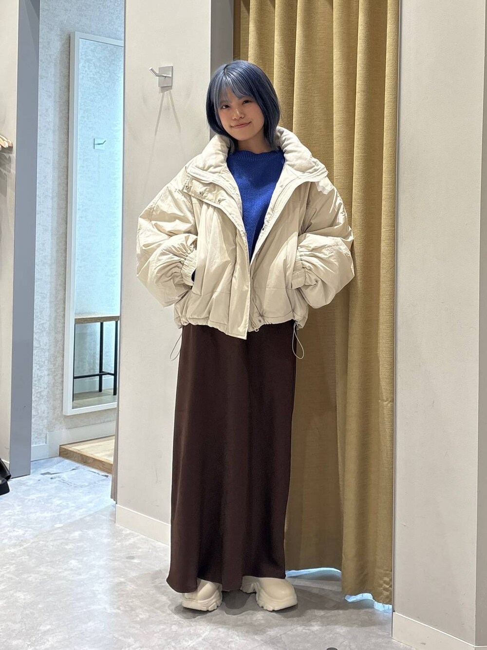 ホワイト系のその他アウター、ホワイト系のブーツ、ブラウン系のスカートを着用したレディースの冬コーディネートの1枚目の写真