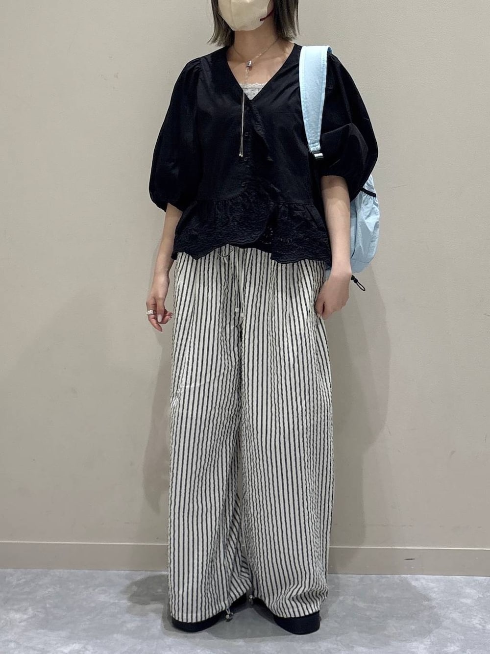 シルバー系のサンダル、ブラック系のシャツ/ブラウス、ブルー系のバックパック/リュックを着用したレディースの春コーディネートの1枚目の写真