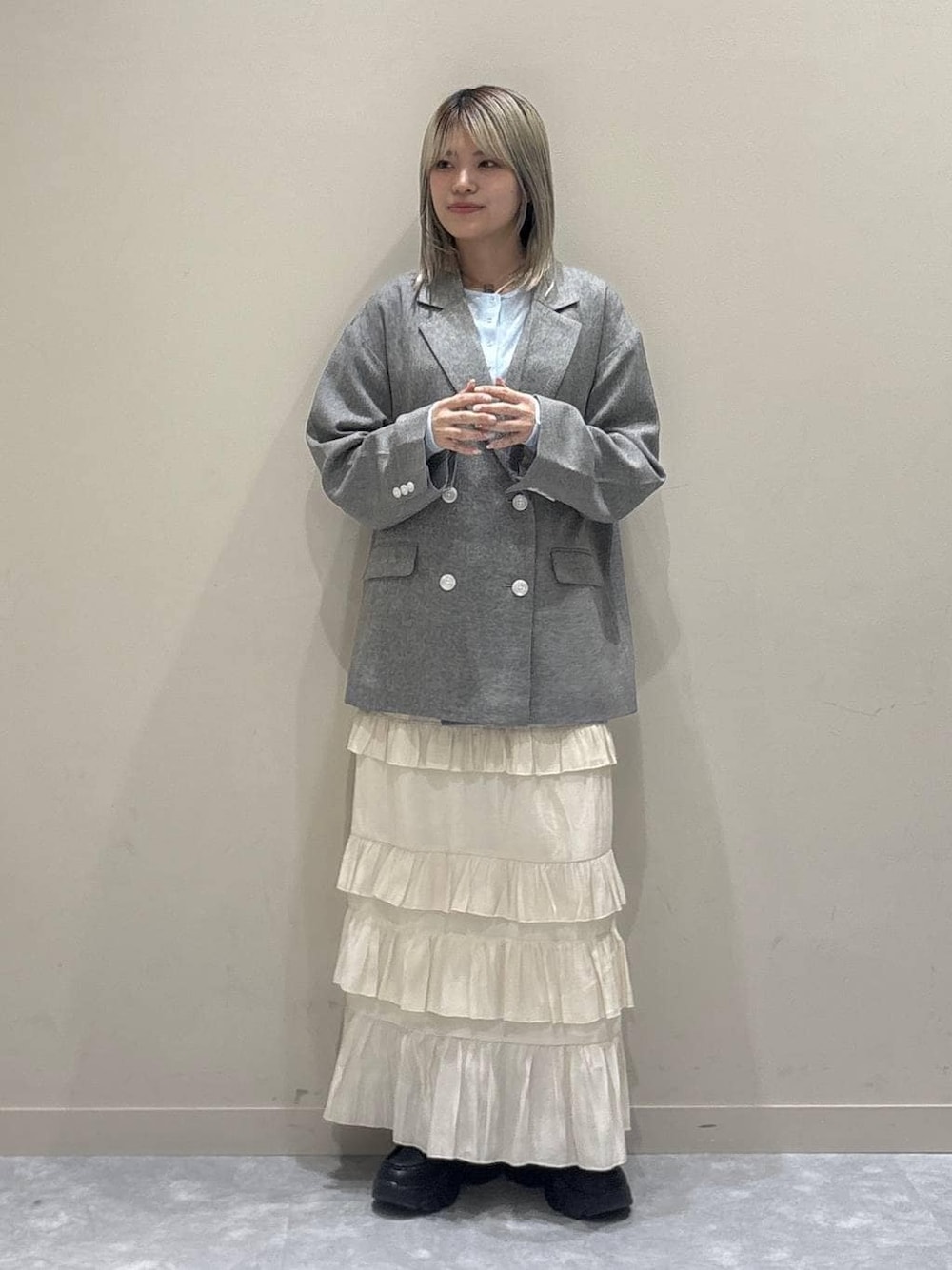 グレー系のテーラードジャケット、ブラック系のローファー、ブルー系のTシャツ/カットソーを着用したレディースの春コーディネートの1枚目の写真