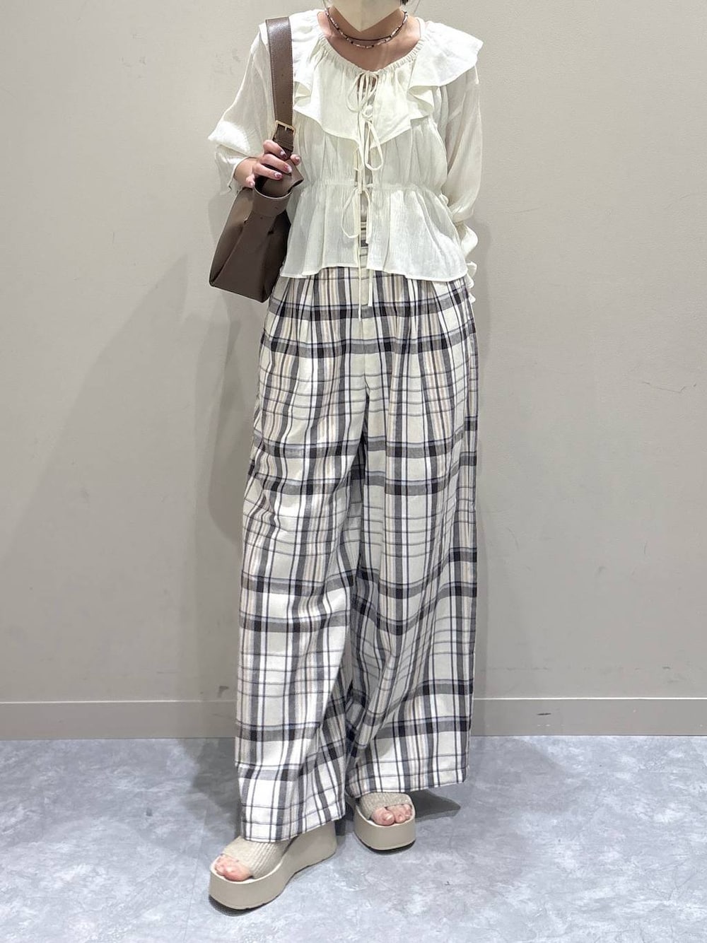 ホワイト系のTシャツ/カットソー、ベージュ系のスラックス、ホワイト系のサンダルを着用したレディースの夏コーディネートの1枚目の写真