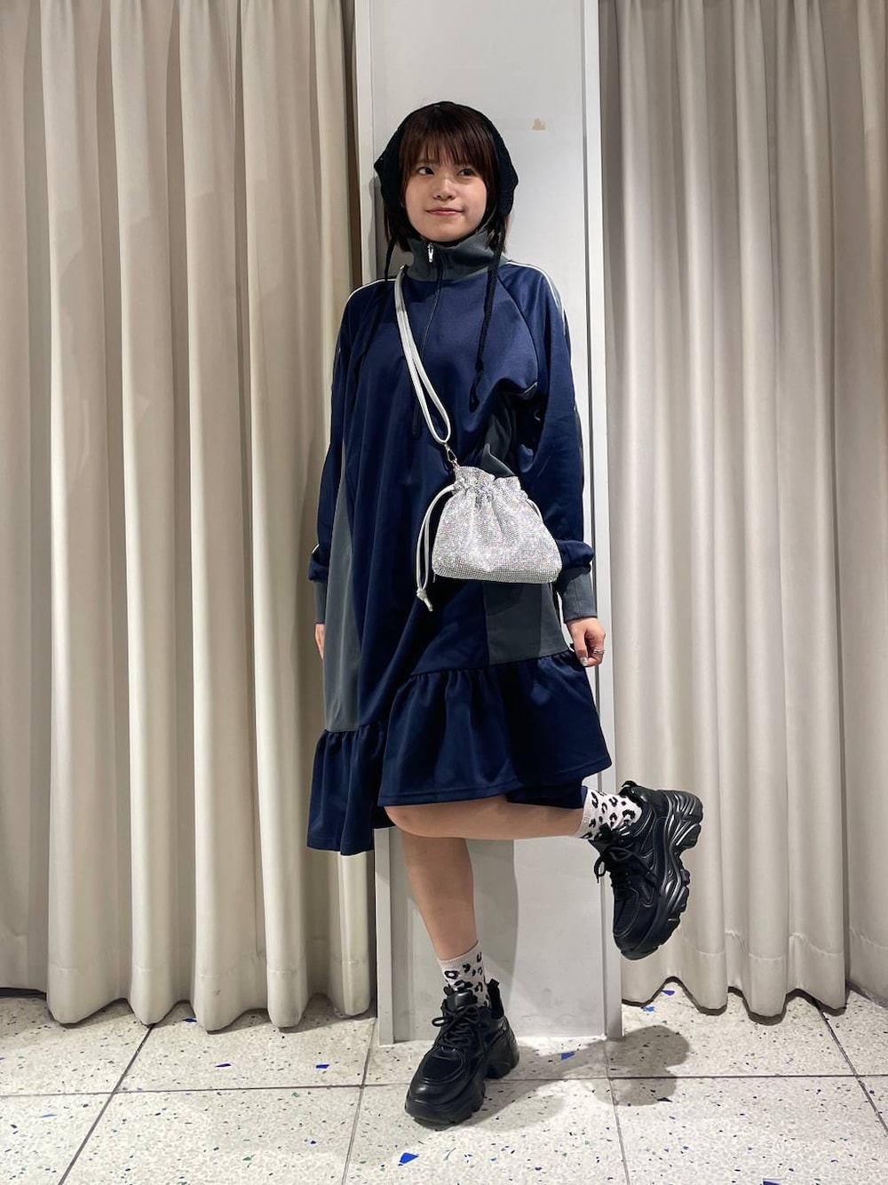 シルバー系のショルダーバッグ、ブラック系のスニーカー、ブルー系のワンピースを着用したレディースの夏コーディネートの1枚目の写真