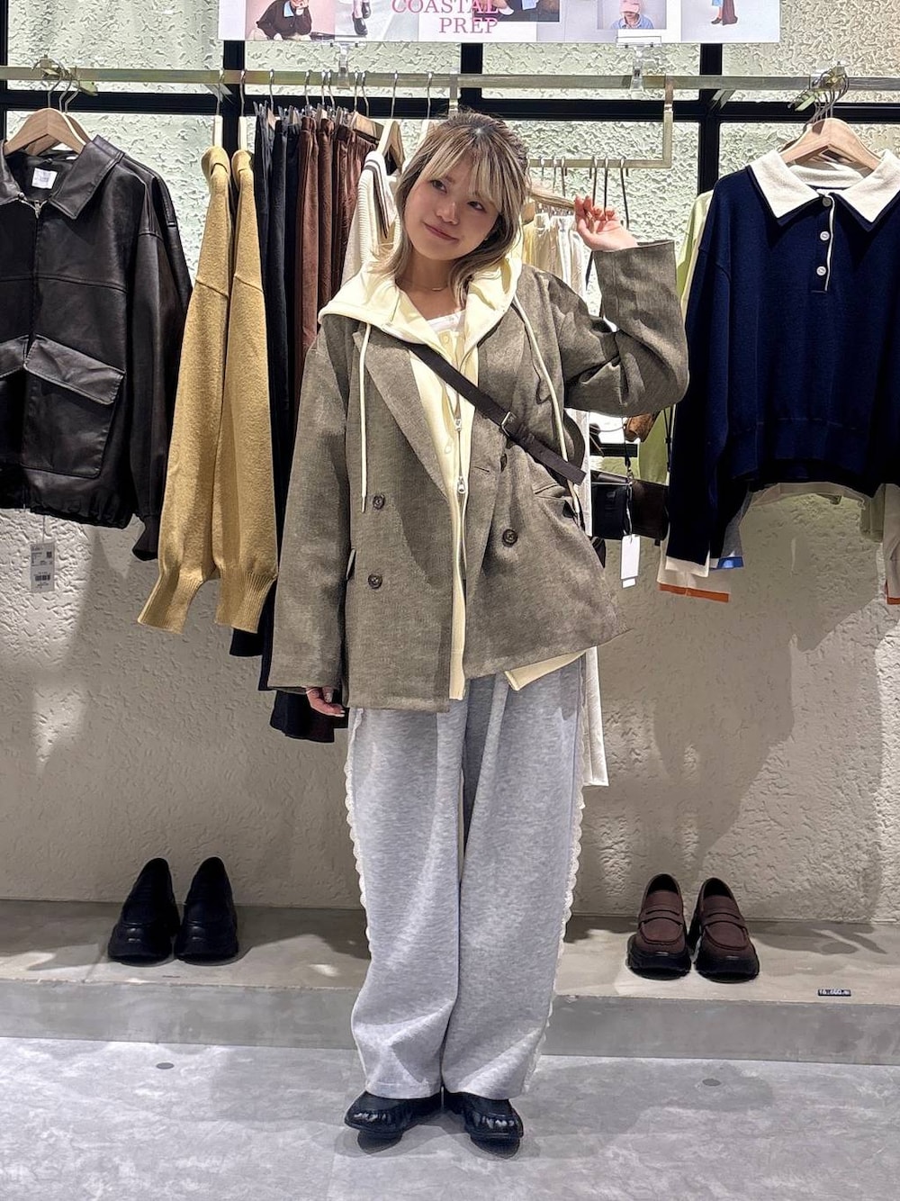 グレー系のスウェットパンツ、イエロー系のパーカー、ブラウン系のテーラードジャケットを着用したレディースの春コーディネートの1枚目の写真