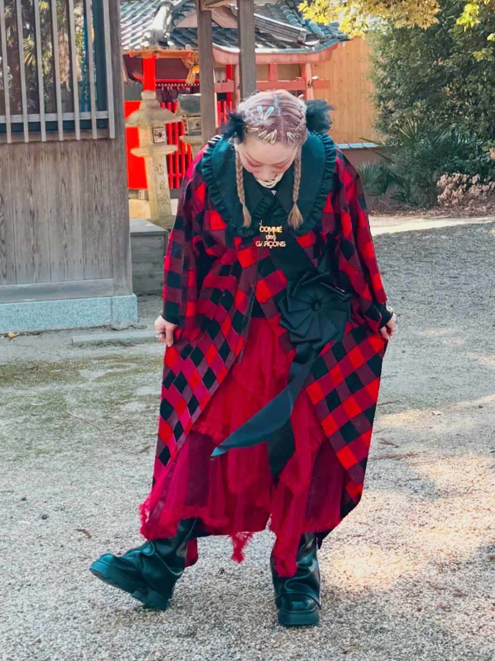 レッド系のスカート、ブラック系のシューズ、ブラック系のファッション雑貨を着用したレディースの冬コーディネートの1枚目の写真