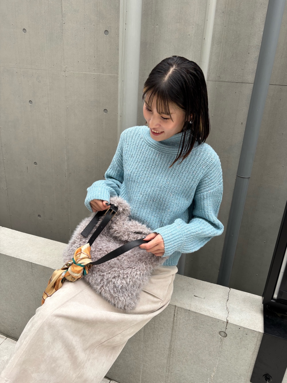 ブルー系のニット/セーター、ベージュ系のスカートを着用したレディースの秋コーディネートの1枚目の写真