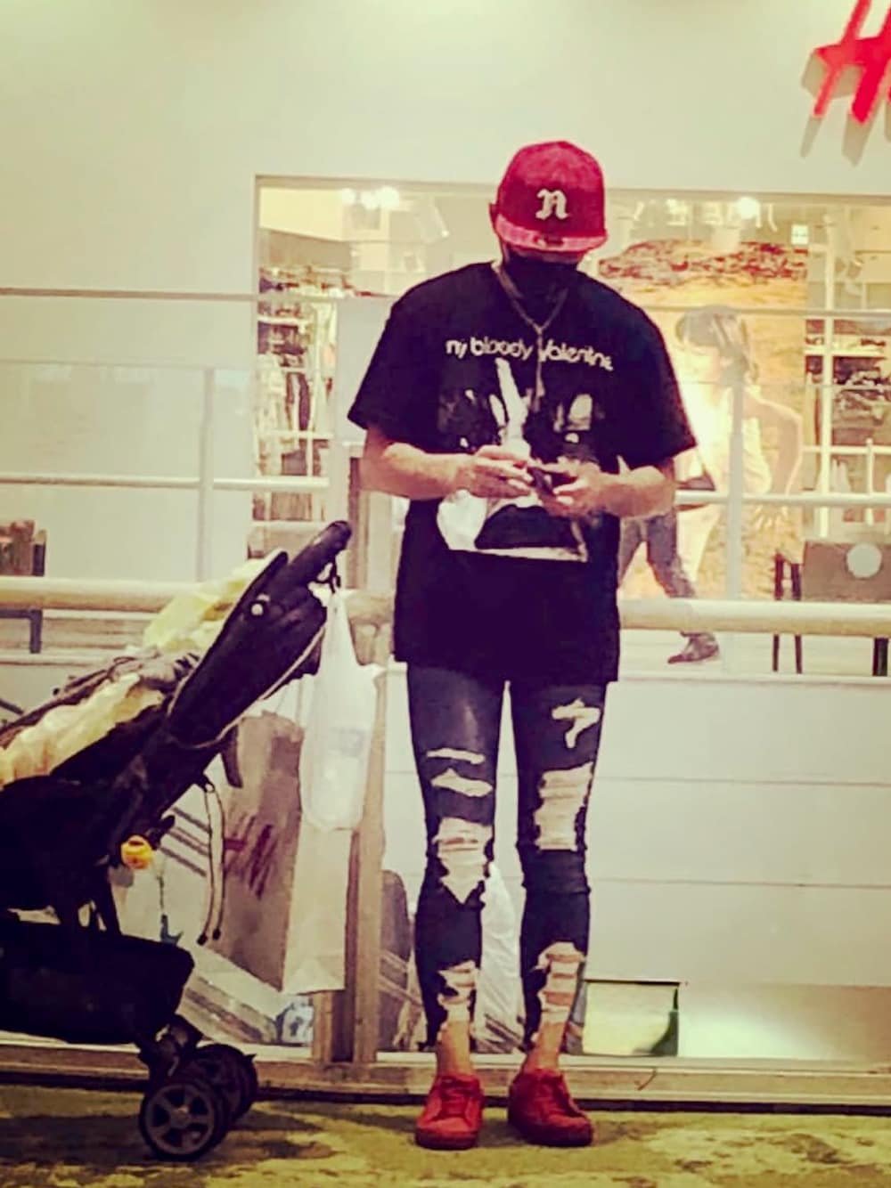 ブラック系のTシャツ/カットソー、ブルー系のデニムパンツ、レッド系のスニーカーを着用したメンズの春コーディネートの1枚目の写真