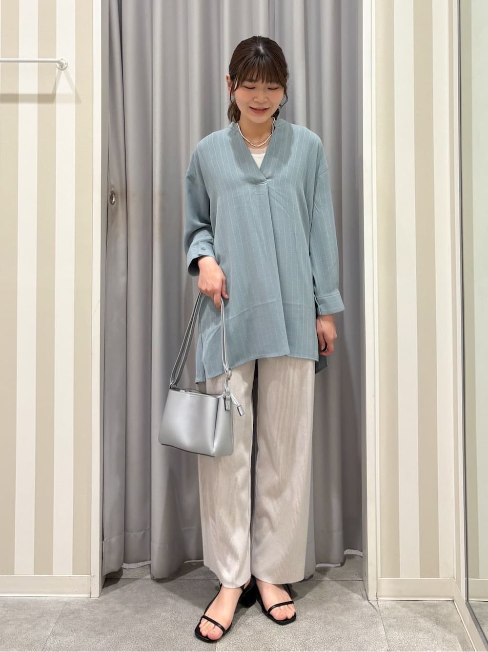 グリーン系のチュニック、ホワイト系のTシャツ/カットソー、ベージュ系のその他パンツを着用したレディースの春コーディネートの1枚目の写真
