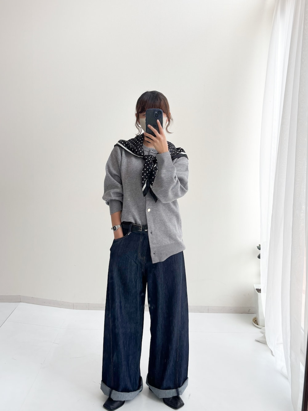 グレー系のカーディガン/ボレロ、ブルー系のデニムパンツ、ブラック系のマフラーを着用したレディースの秋コーディネートの1枚目の写真