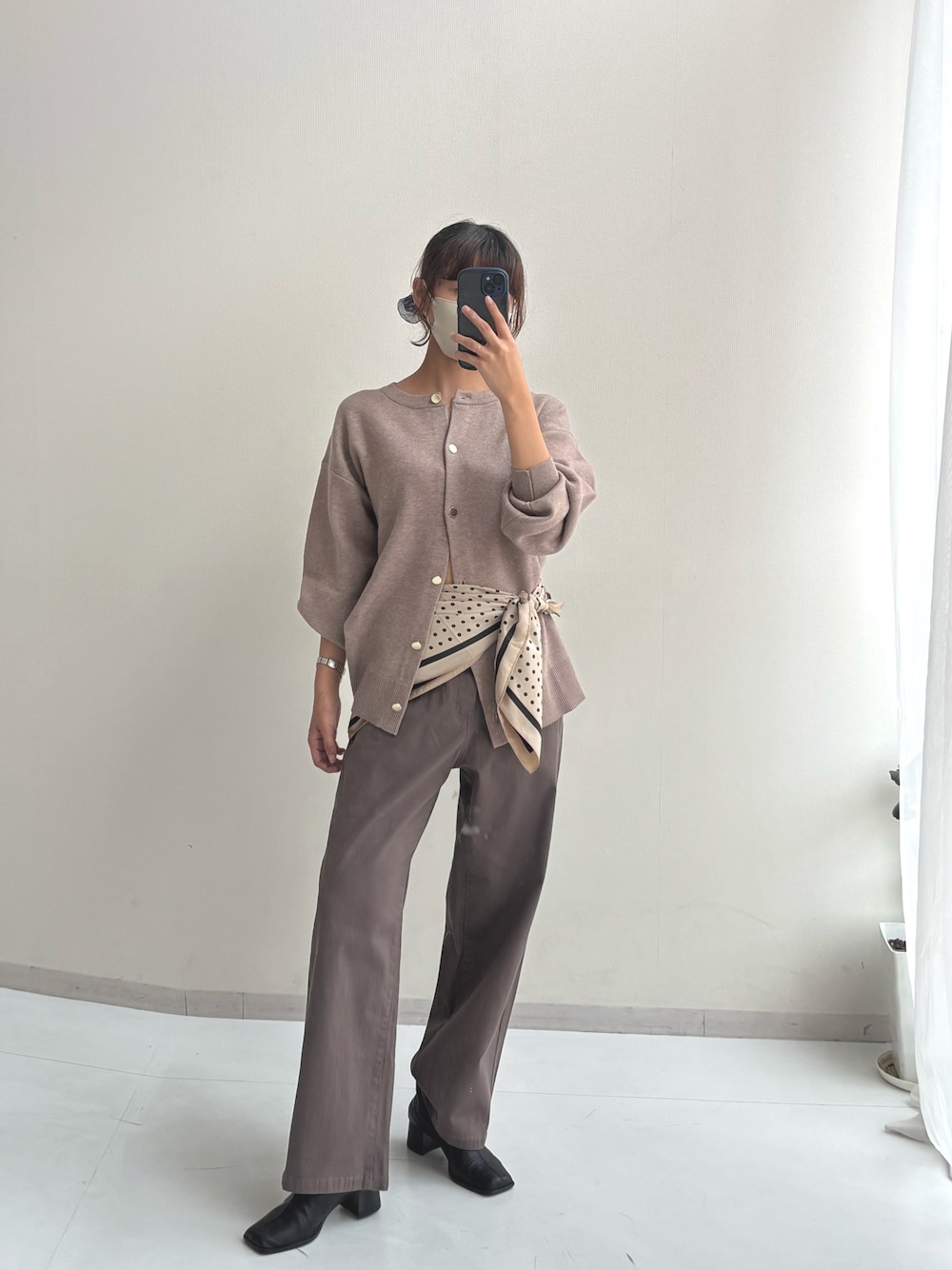 ブラウン系のパンツ、ベージュ系のカーディガン/ボレロ、ベージュ系のマフラーを着用したレディースの秋コーディネートの1枚目の写真