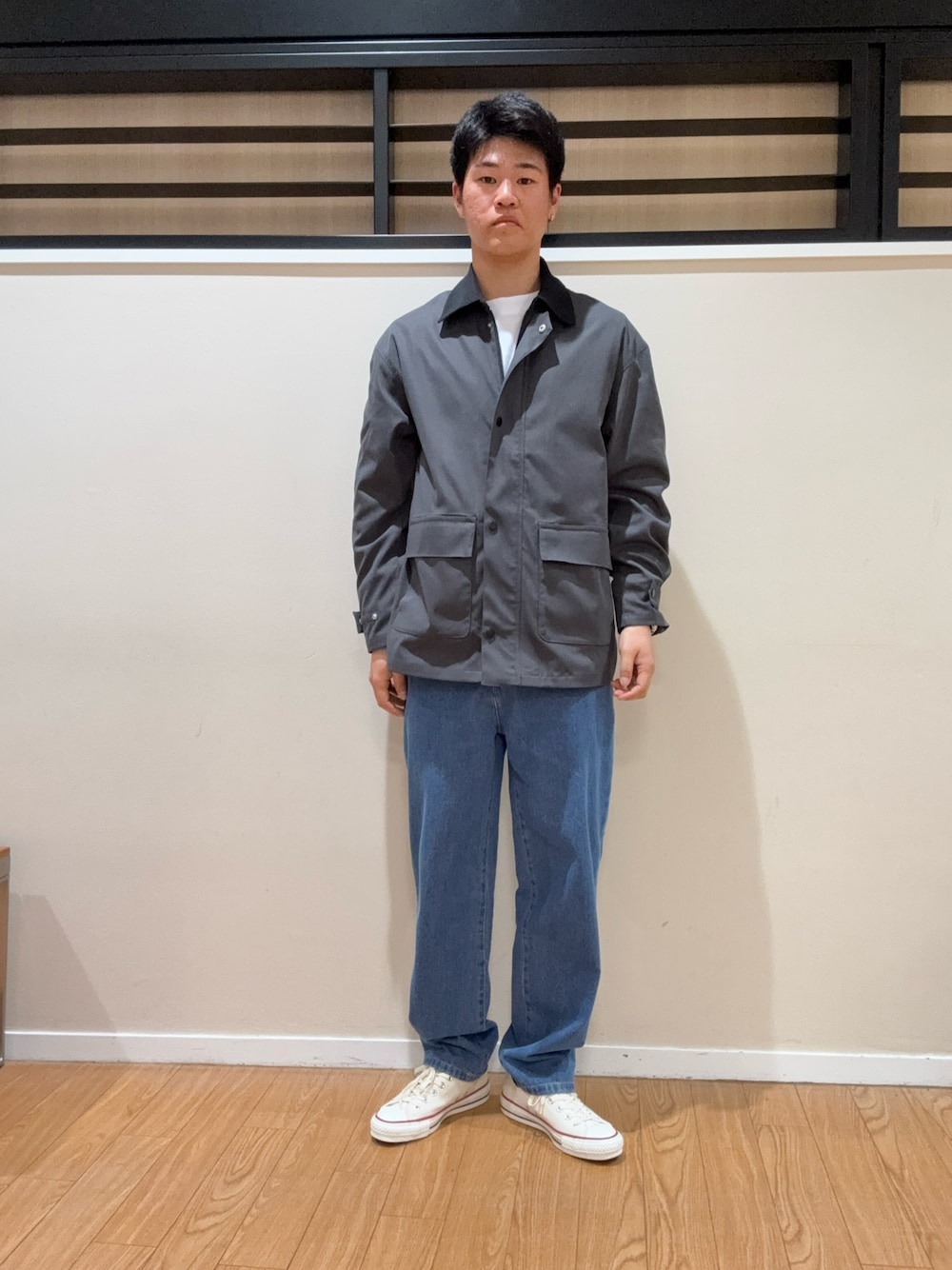 グレー系のその他アウター、ホワイト系のスニーカー、ブルー系のデニムパンツを着用したメンズの春コーディネートの1枚目の写真