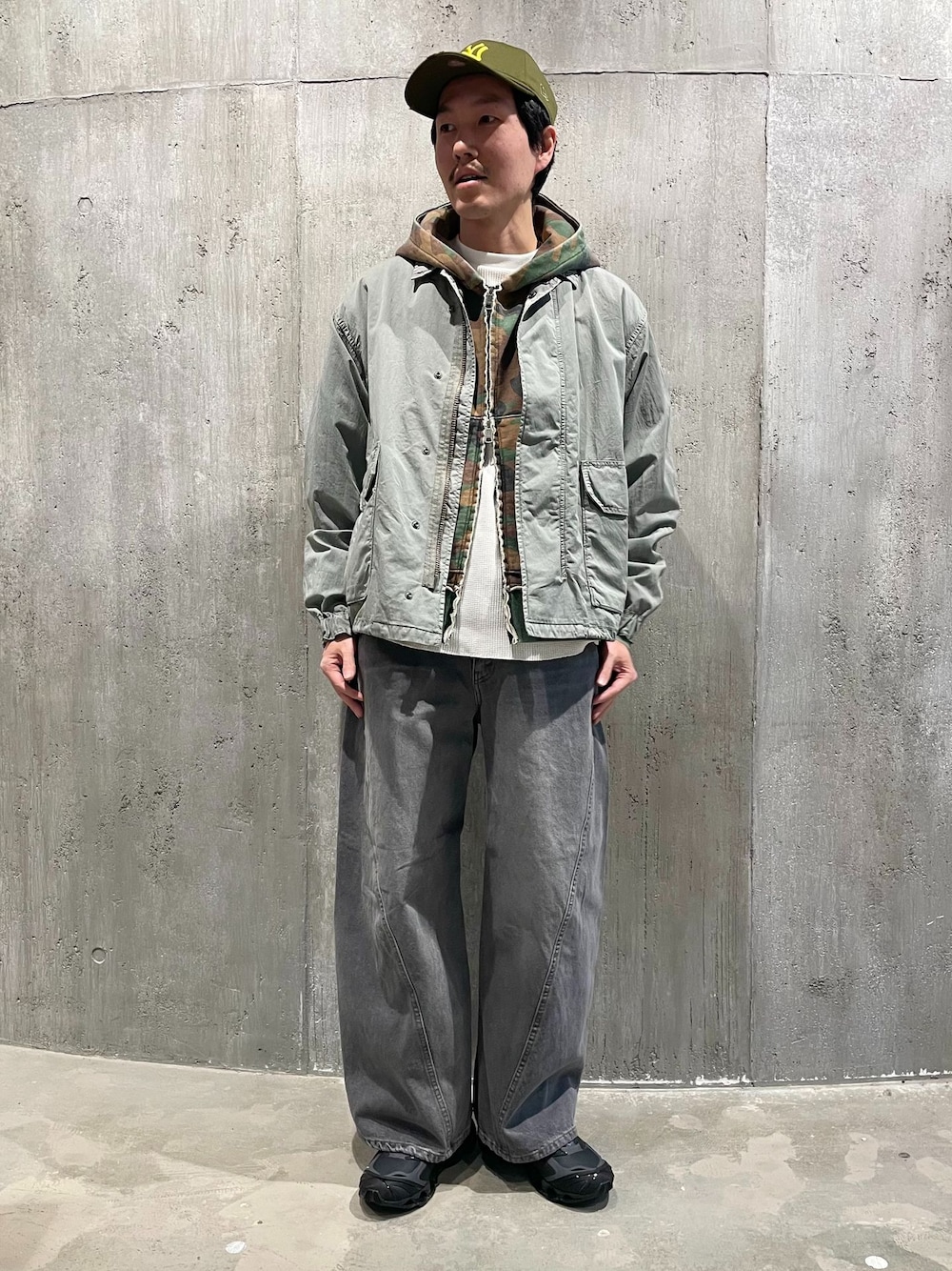 グリーン系のミリタリージャケット、グレー系のデニムパンツ、ホワイト系のTシャツ/カットソーを着用したメンズの冬コーディネートの1枚目の写真