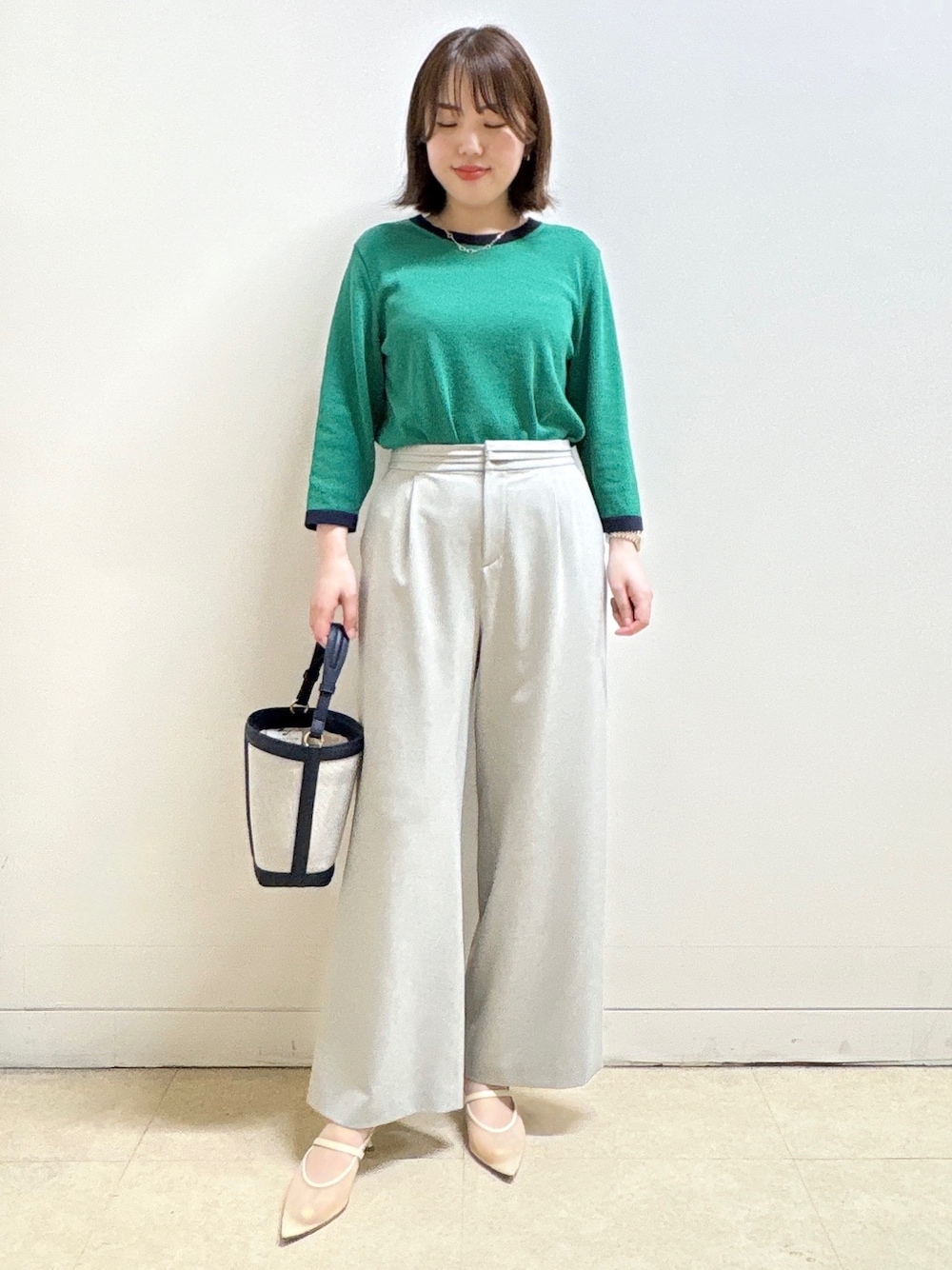グレー系のその他パンツ、ブルー系のショルダーバッグ、グリーン系のニット/セーターを着用したレディースの春コーディネートの1枚目の写真