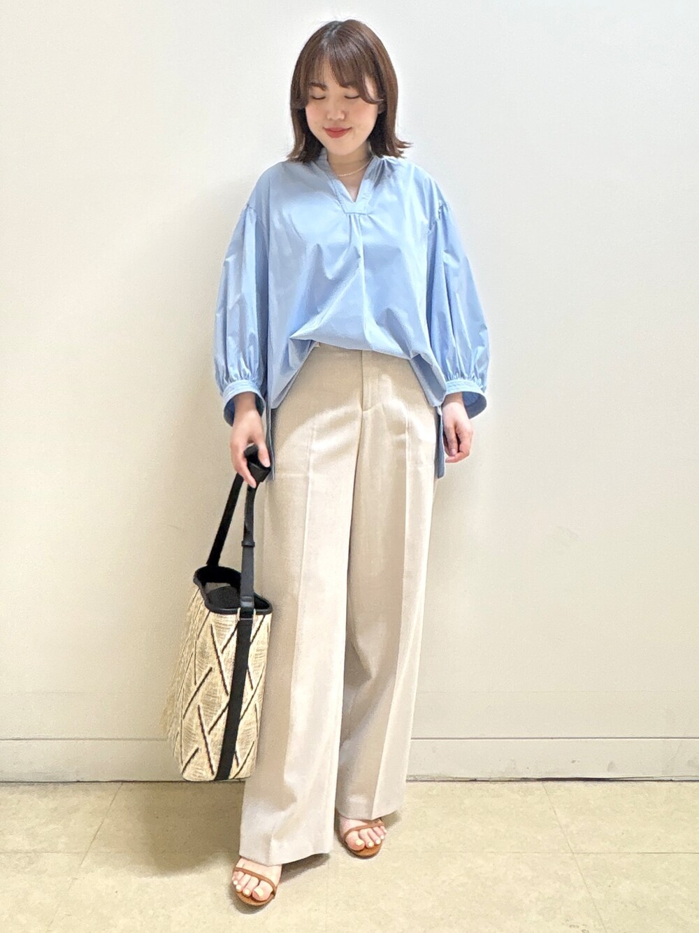 ベージュ系のショルダーバッグ、ブルー系のシャツ/ブラウス、ベージュ系のその他パンツを着用したレディースの春コーディネートの1枚目の写真
