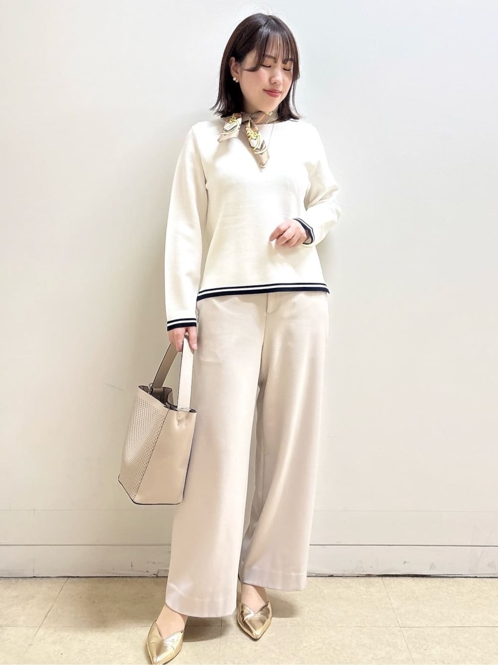 ベージュ系のその他パンツ、ホワイト系のニット/セーター、オレンジ系のカーディガン/ボレロを着用したレディースの冬コーディネートの1枚目の写真