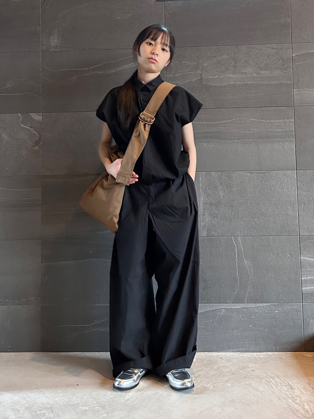 ブラック系のシャツ/ブラウス、ブラック系のパンツ、ブラウン系のショルダーバッグを着用したキッズの春コーディネートの1枚目の写真