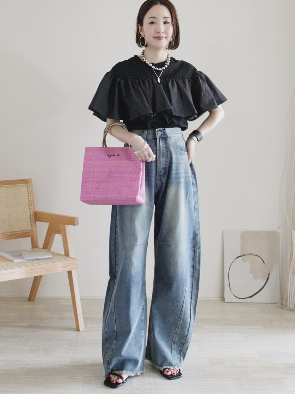 ブルー系のデニムパンツ、ブラック系のTシャツ/カットソー、ピンク系のハンドバッグを着用したレディースの夏コーディネートの1枚目の写真